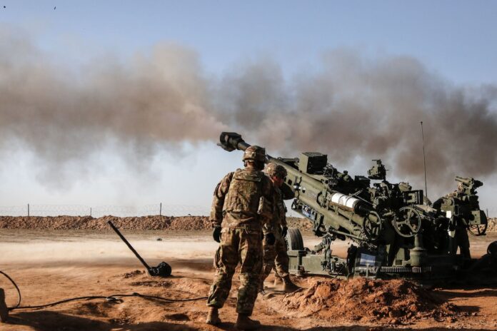 Soldiers fire a military weapon.